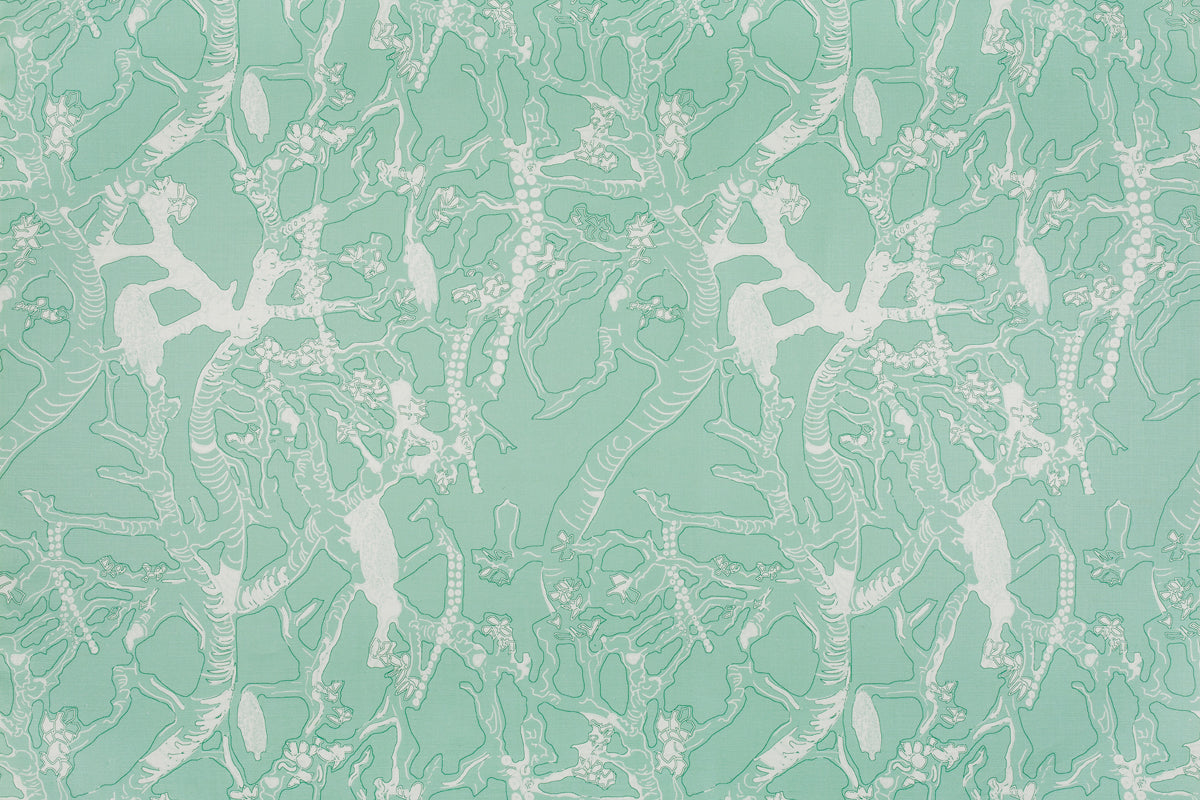 Detail of fabric in a branch and blossom print in white and green on a light green field.