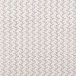 Panel of embroidered fabric in a linear geometric print in white and navy on a cream field.