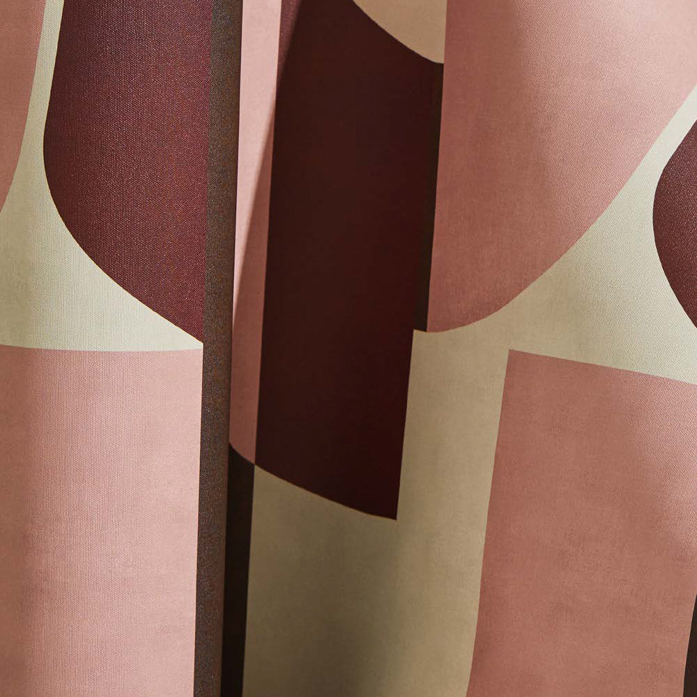 Draped wallpaper yardage in a curvilinear geometric grid print in shades of pink and maroon on a cream field.