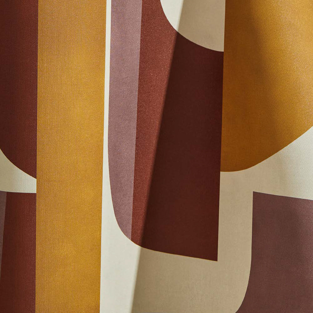 Draped wallpaper yardage in a curvilinear geometric grid print in shades of mustard, rust and purple on a cream field.