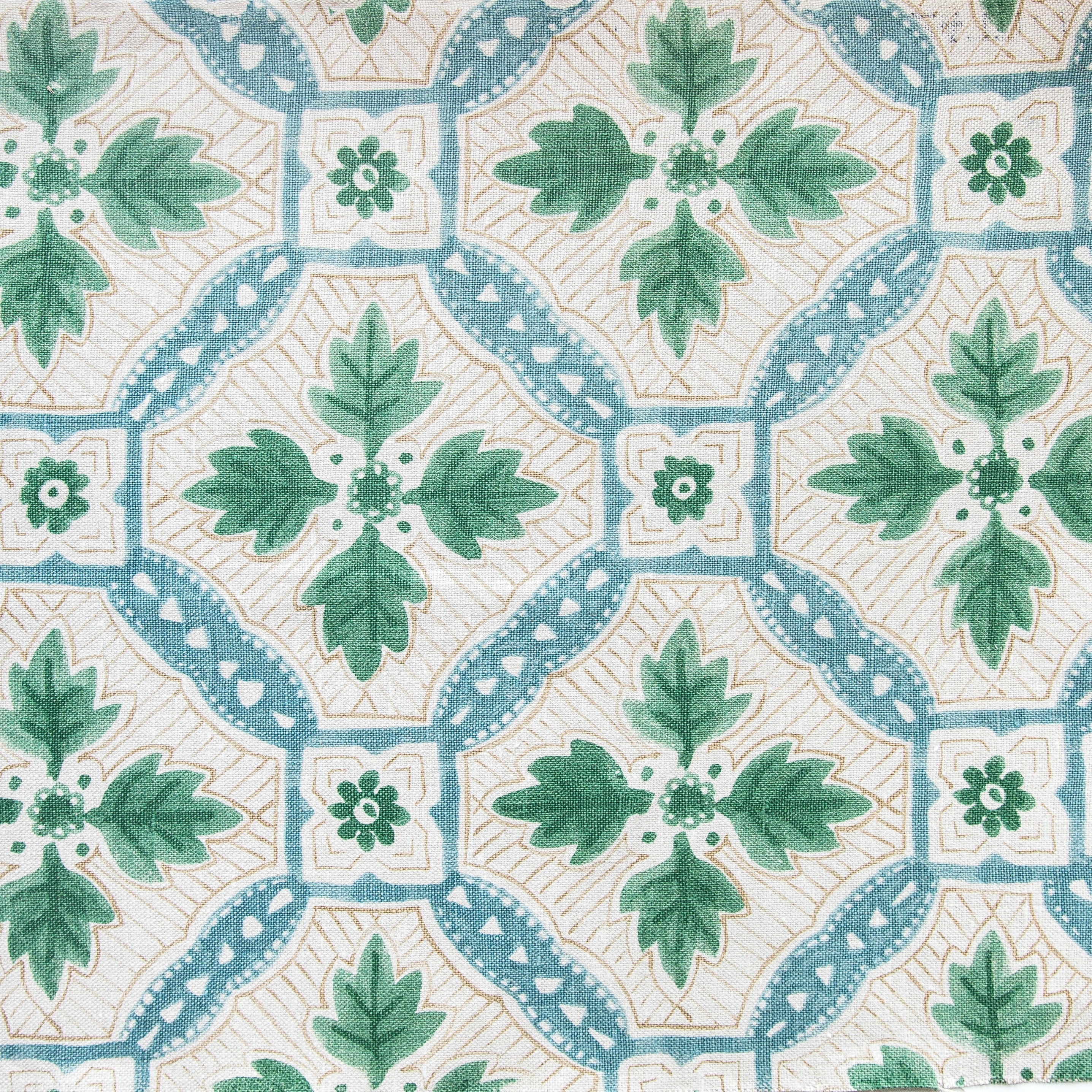Detail of fabric in a painterly botanical grid in shades of blue, green and tan on a cream field.