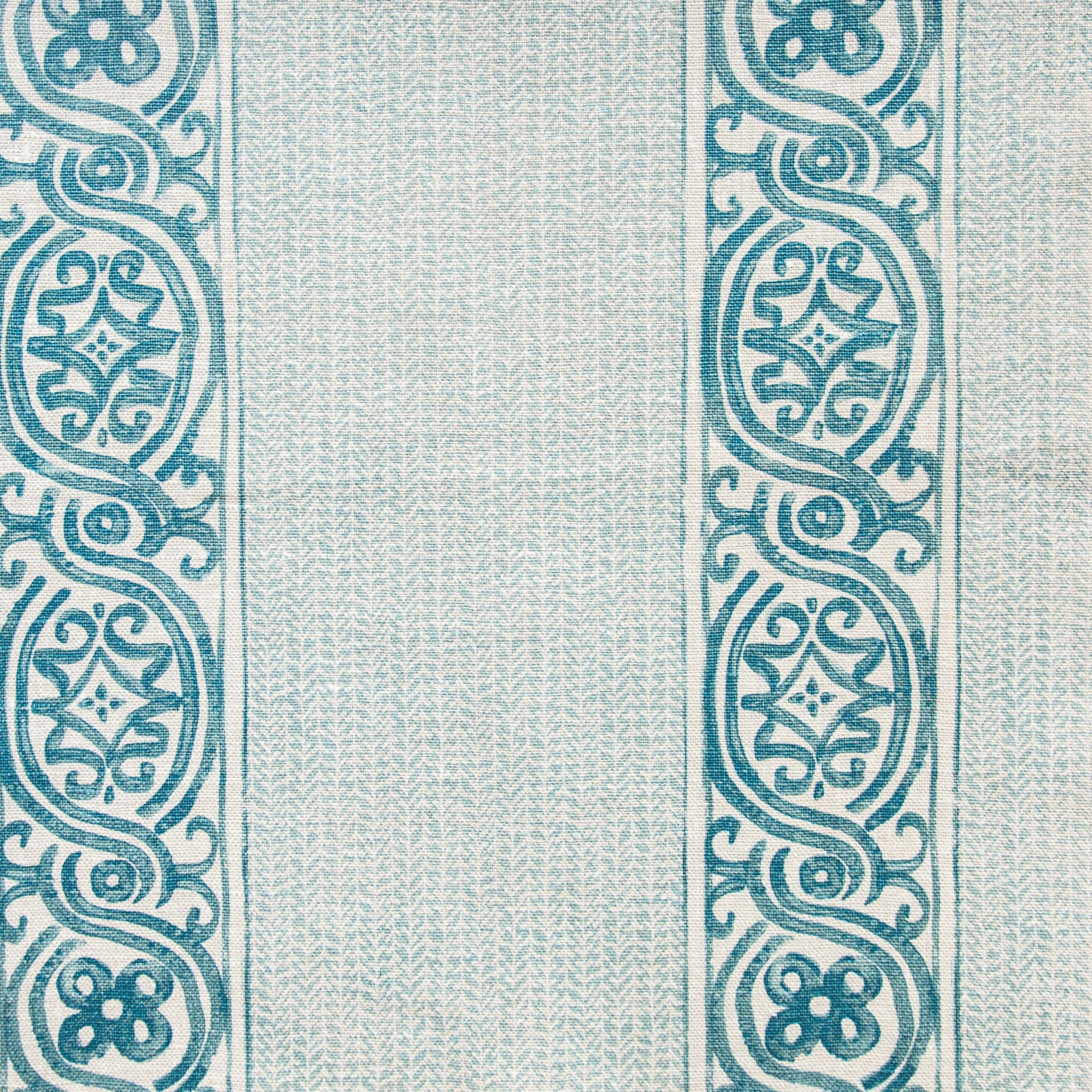 Detail of fabric in a painterly stripe print in shades of turquoise on a cream field.