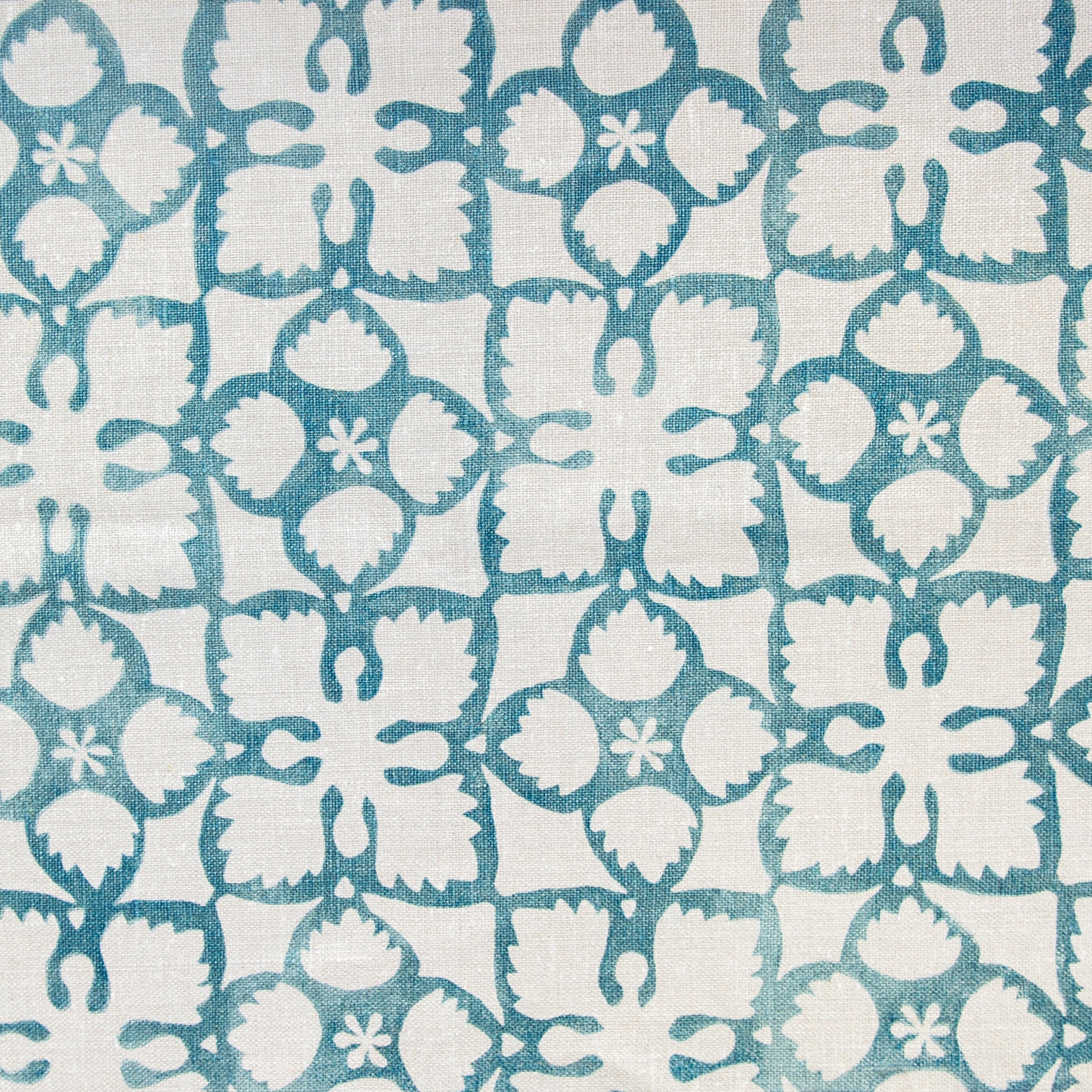 Detail of fabric in a botanical lattice print in teal on a cream field.