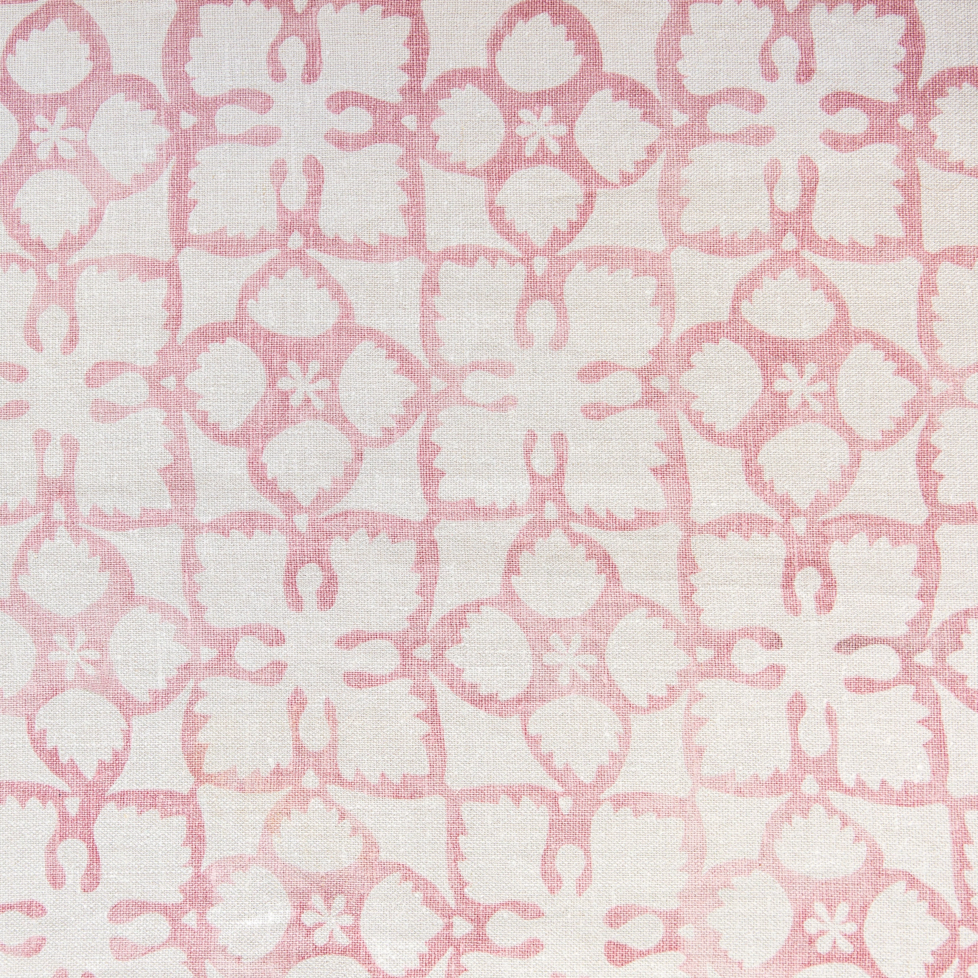 Detail of fabric in a botanical lattice print in pink on a cream field.