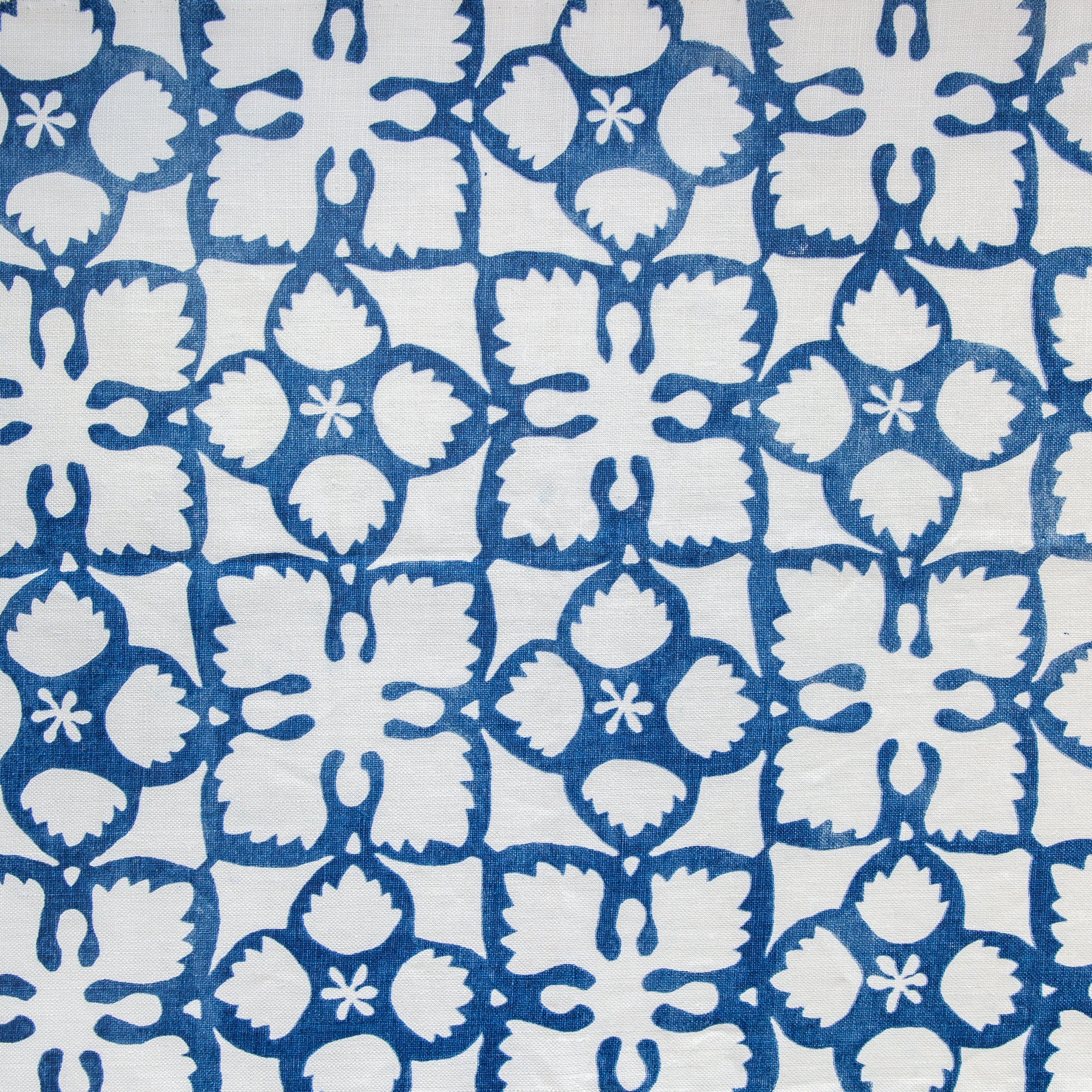 Detail of fabric in a botanical lattice print in blue on a white field.