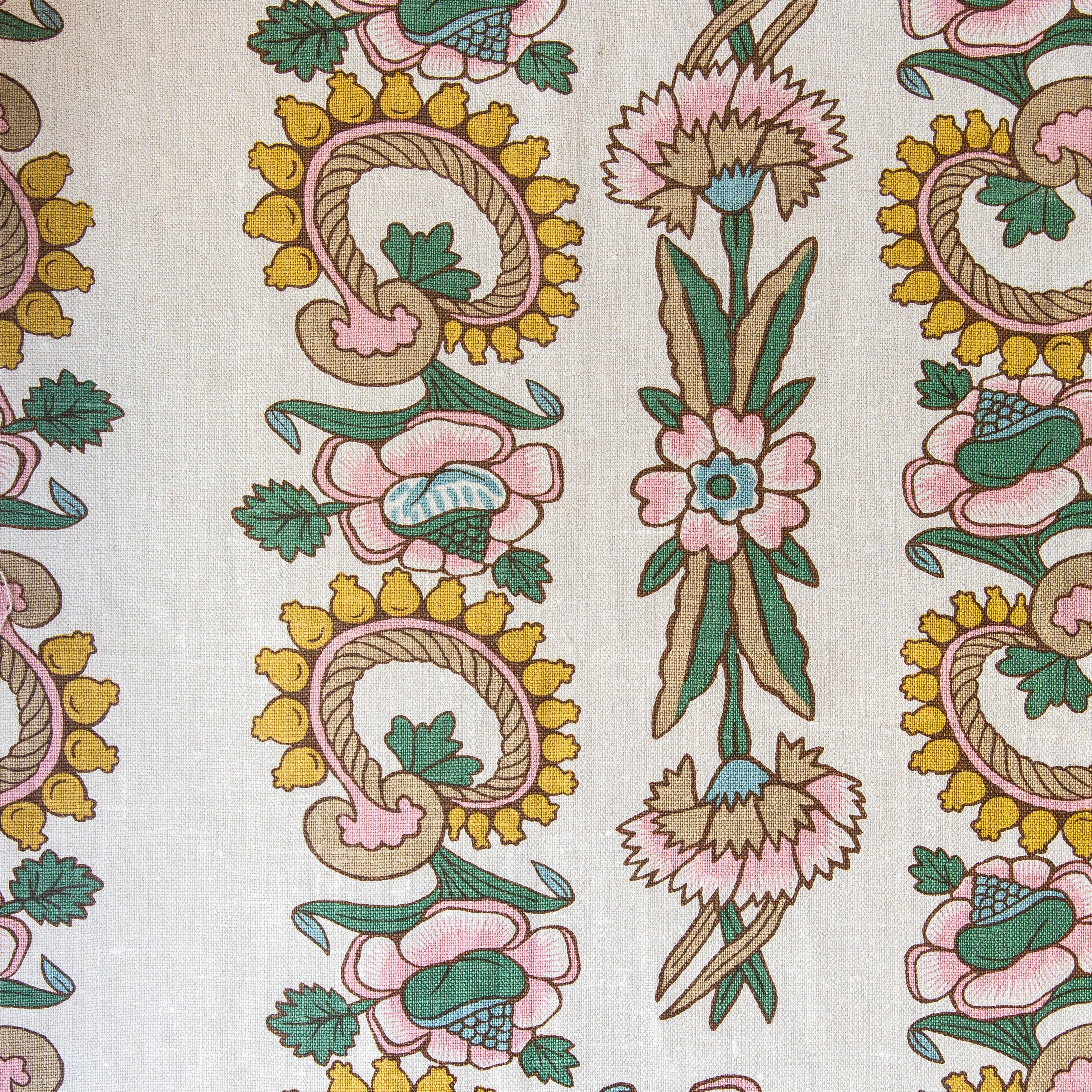Detail of fabric in a dense floral stripe in green, brown and pink on a cream field.