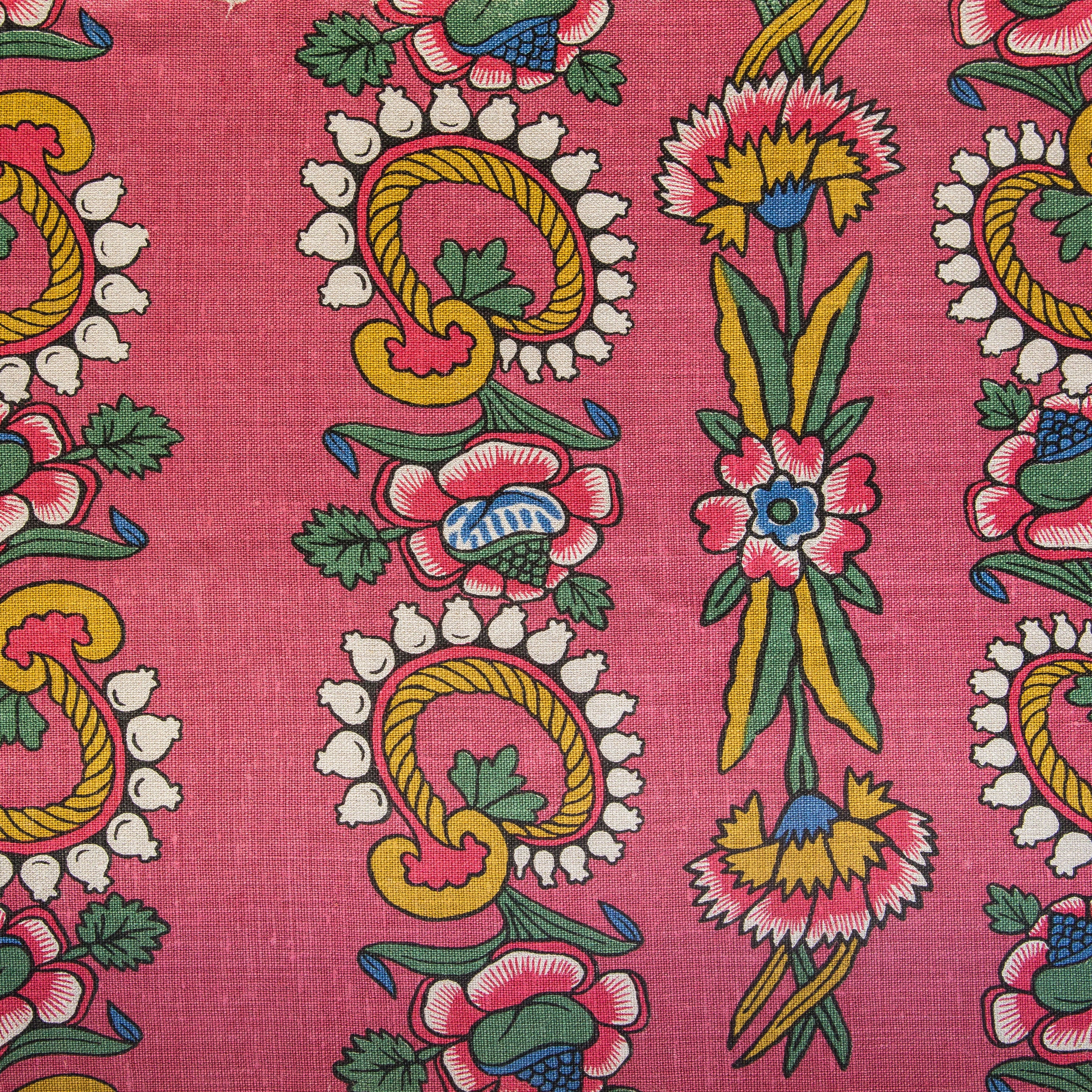 Detail of fabric in a dense floral stripe in pink, yellow and green on a pink field.
