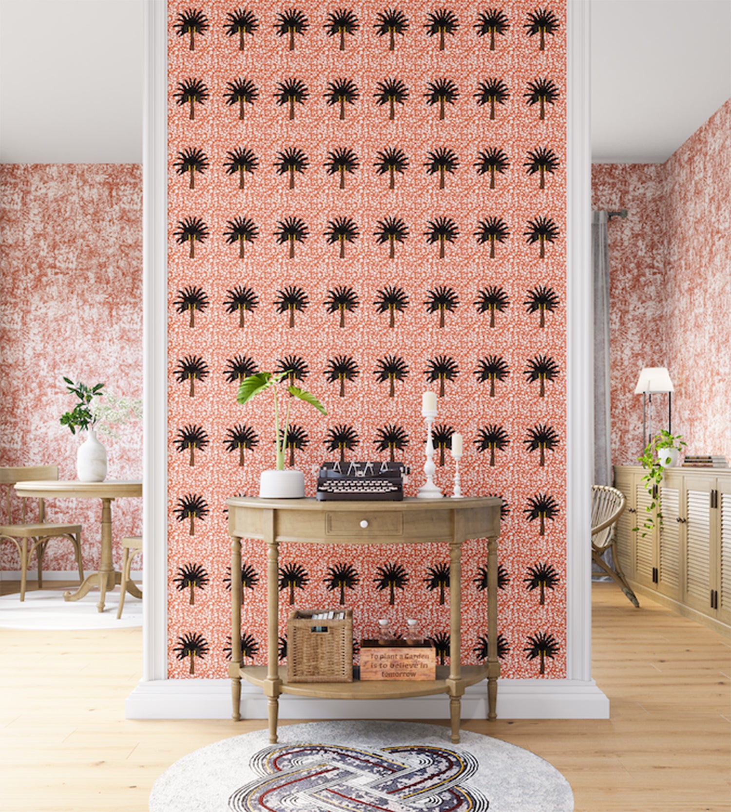 A maximalist living space with an accent wall papered in a repeating palm tree print on a mottled white and coral field.