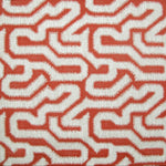 Detail of wallpaper in a playful meandering print in cream on a red field.
