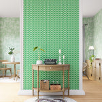 A maximalist living space with an accent wall papered in an intricate lattice print in green on a cream field.