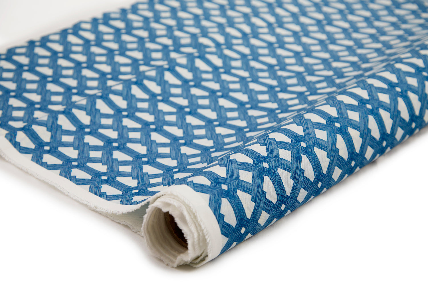 Partially unrolled fabric in an intricate lattice print in navy on a cream field.