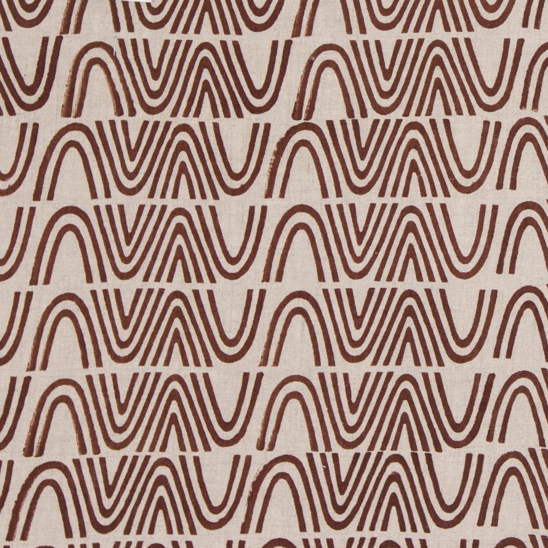 Detail of fabric in an abstract curvilinear stripe in rust on a tan field.