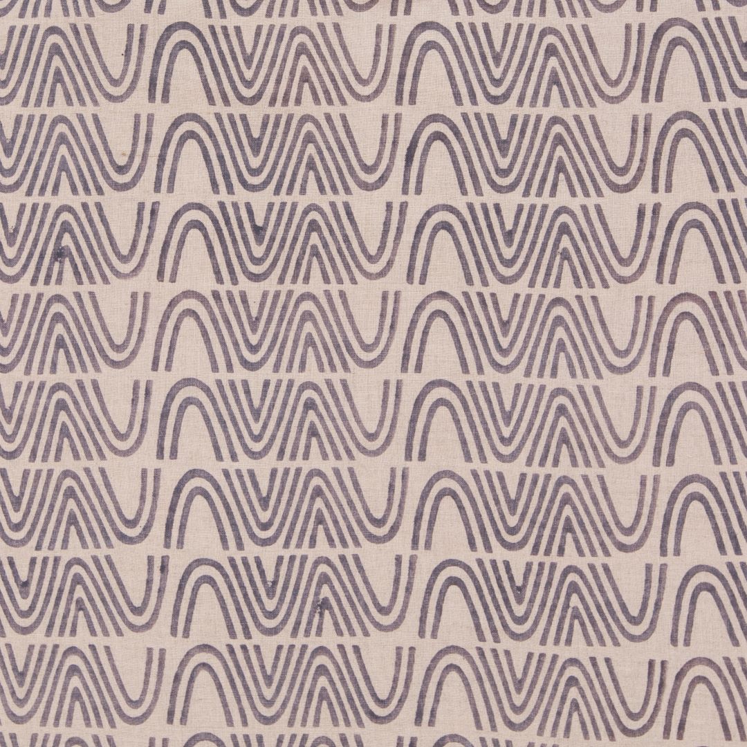 Detail of fabric in an abstract curvilinear stripe in gray on a tan field.