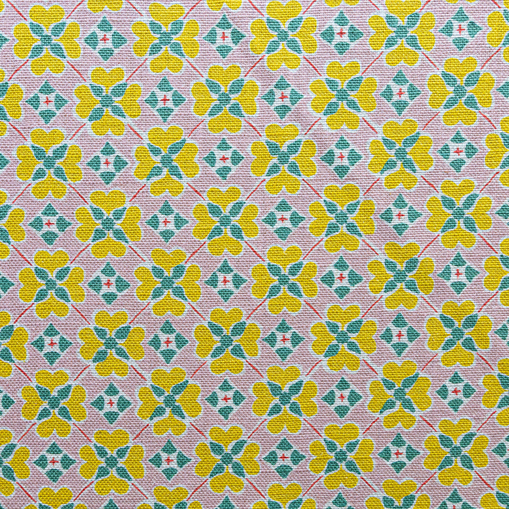 Detail of fabric in a floral lattice print in pink, yellow, teal and white.