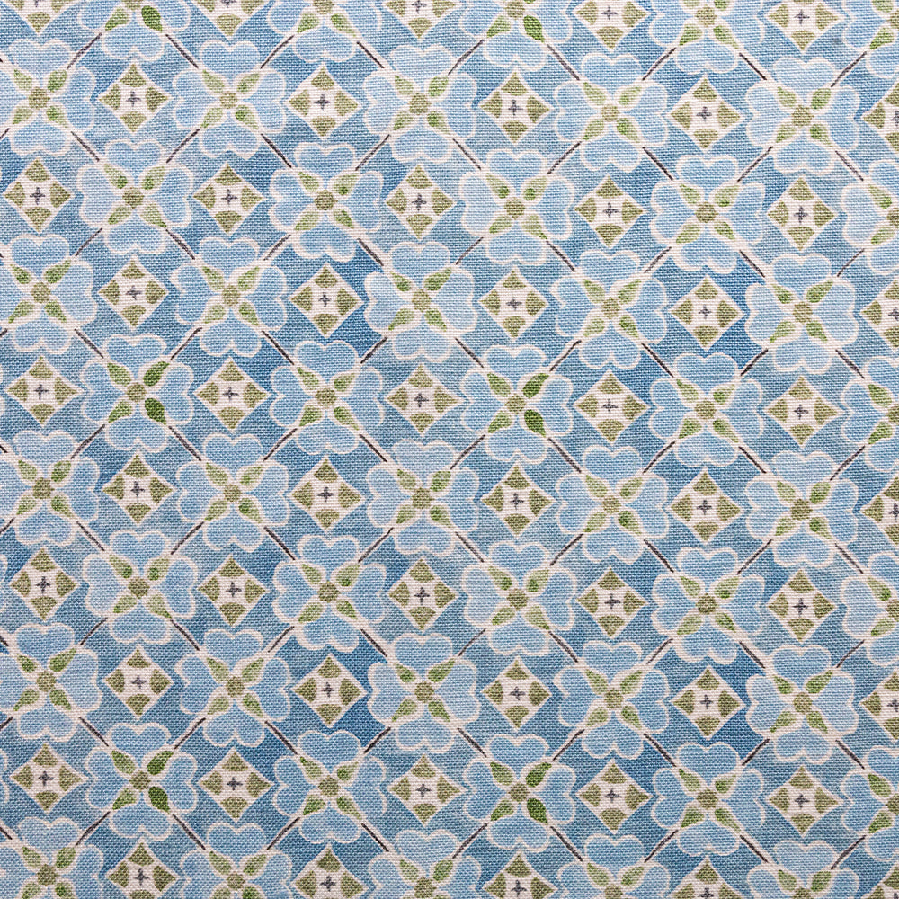 Detail of fabric in a floral lattice print in blue, green and white.