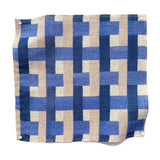 Square fabric swatch in an interlocking checked pattern in shades of tan, blue and navy.