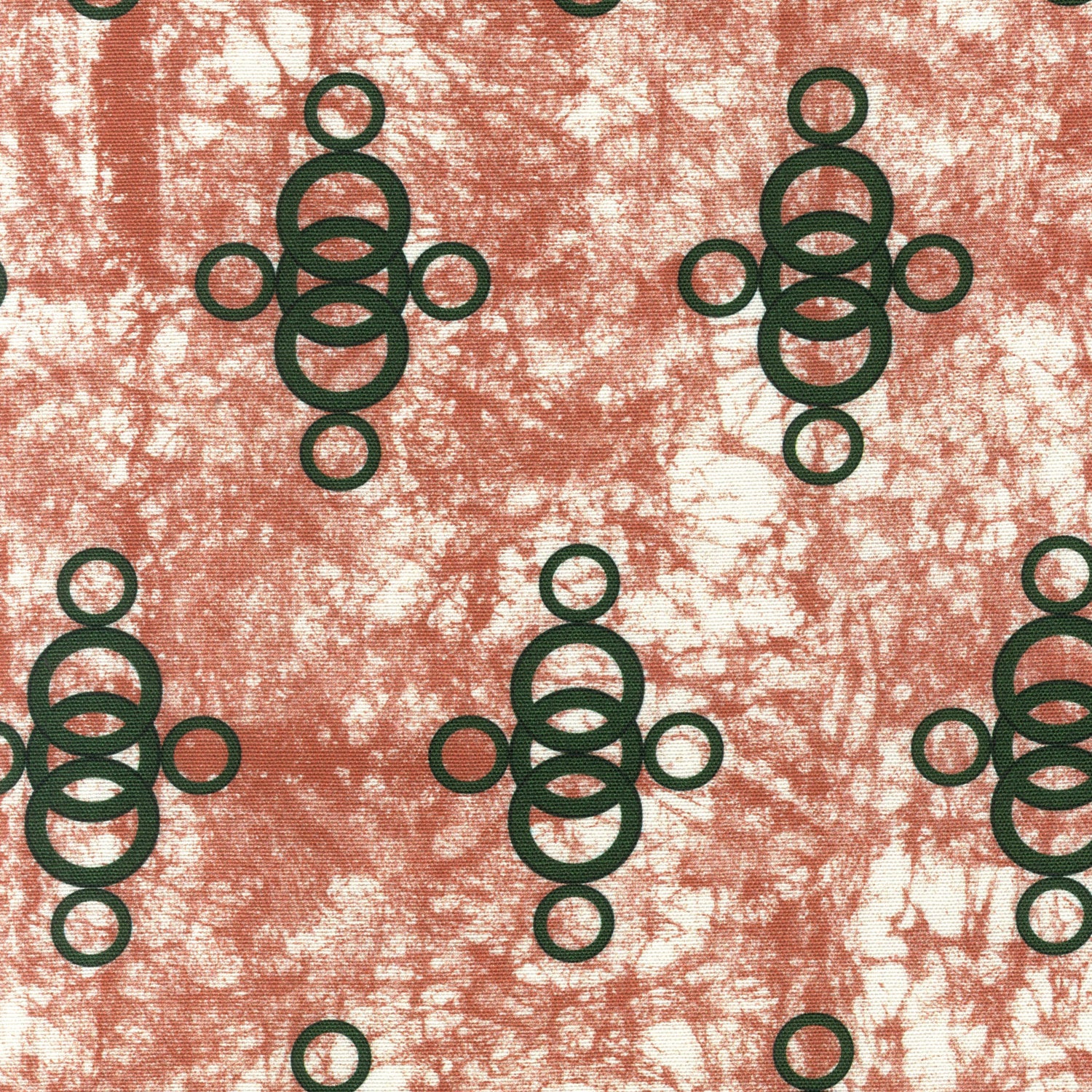 Detail of fabric in a curving lattice print in dark green on a mottled coral field.
