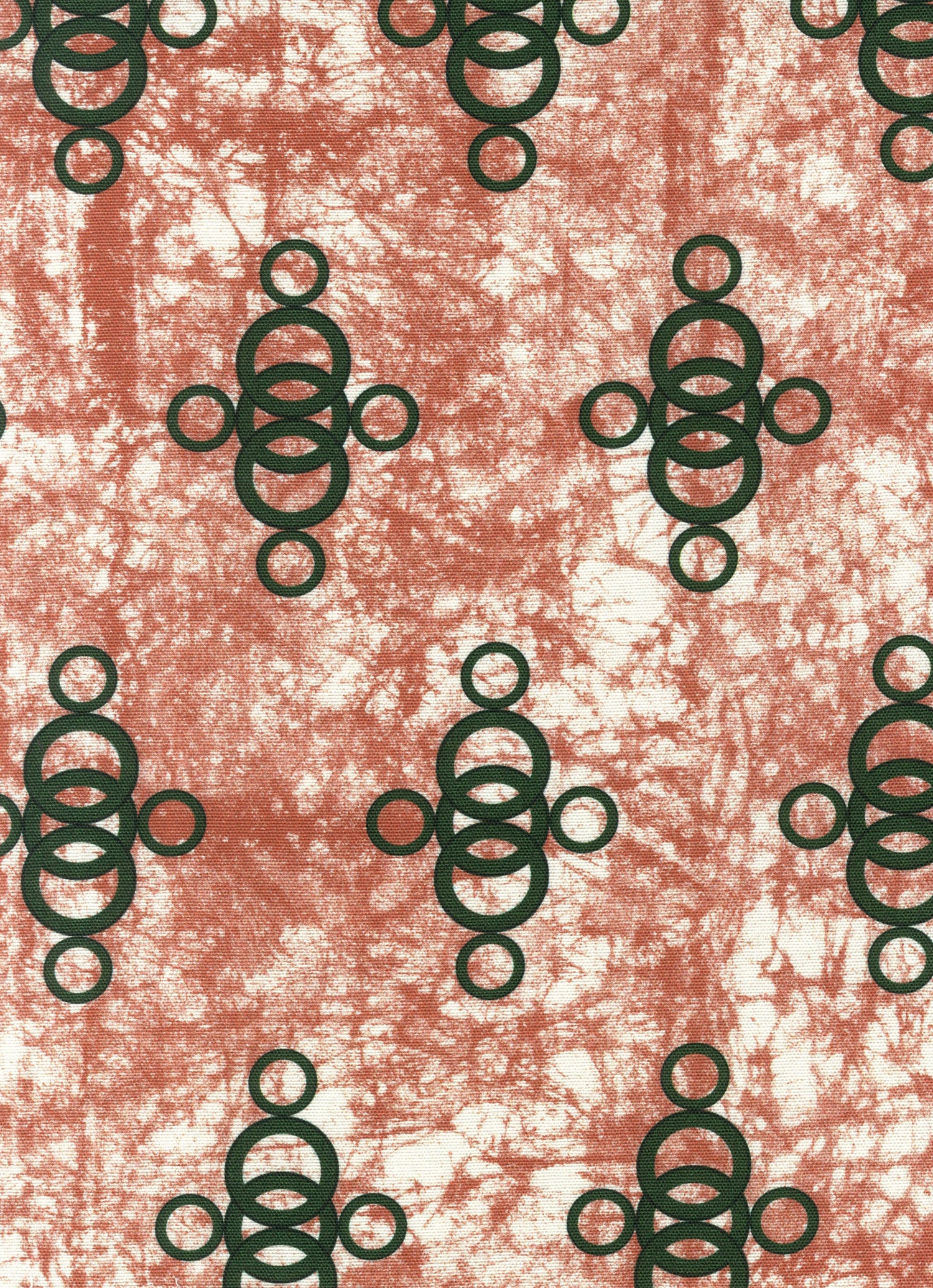 Detail of fabric in a curving lattice print in dark green on a mottled coral field.