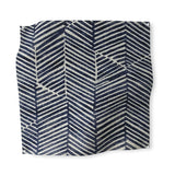 Square fabric swatch in a dense herringbone print in navy on a tan field.