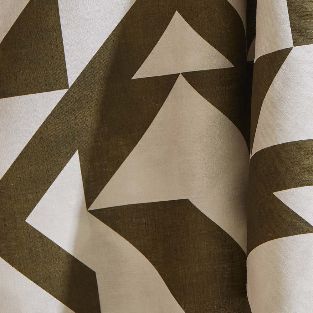 Draped fabric yardage in a large-scale geometric print in brown on a white field.