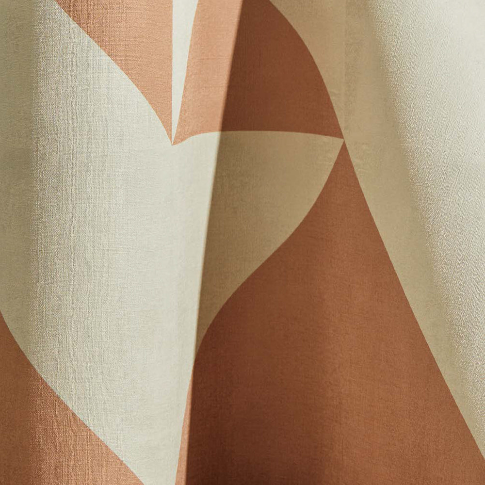 Draped wallpaper yardage in a large-scale geometric print in peach on a cream field.