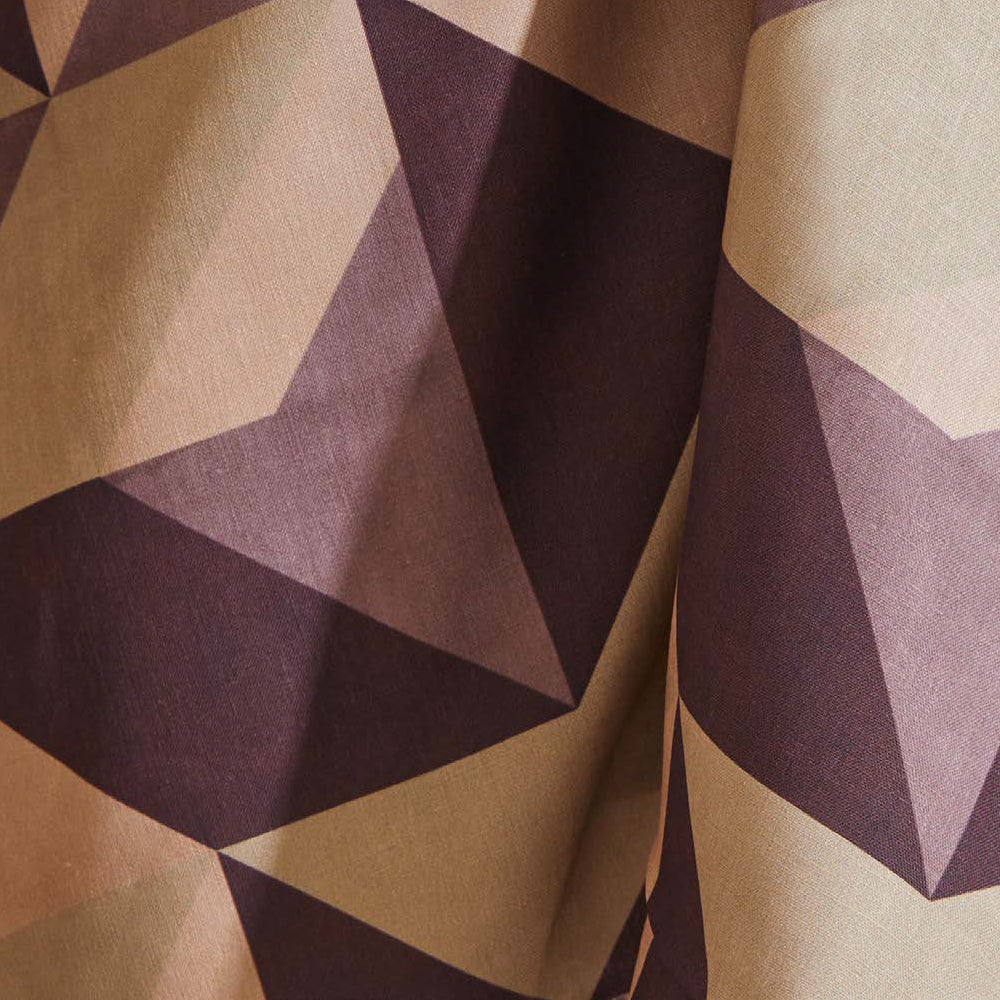 Draped fabric yardage in a large-scale geometric print in cream, tan and purple.