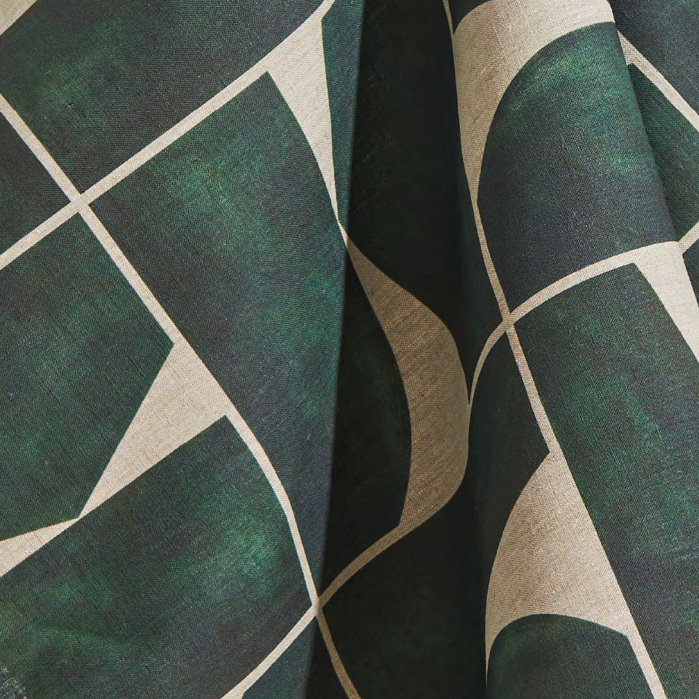 Draped fabric yardage in a large-scale curvilinear geometric print in dark green on a cream field.