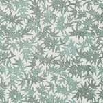 Detail of a printed linen fabric in a repeating bamboo leaf pattern in shades of green on a white field.