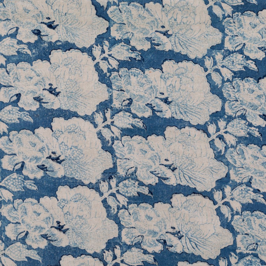 Detail of fabric in a floral print in cream and light blue on a navy field.