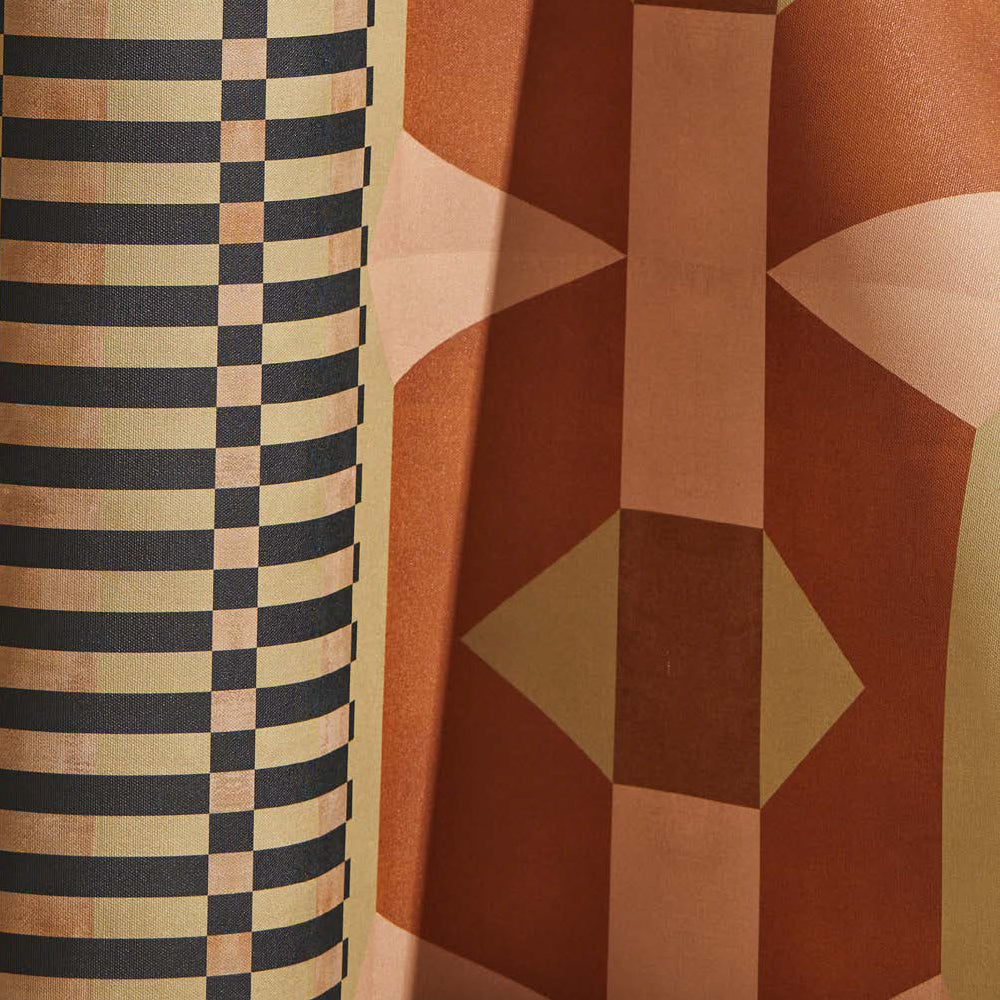 Draped wallpaper yardage in a dense geometric print in shades of peach, yellow and red.