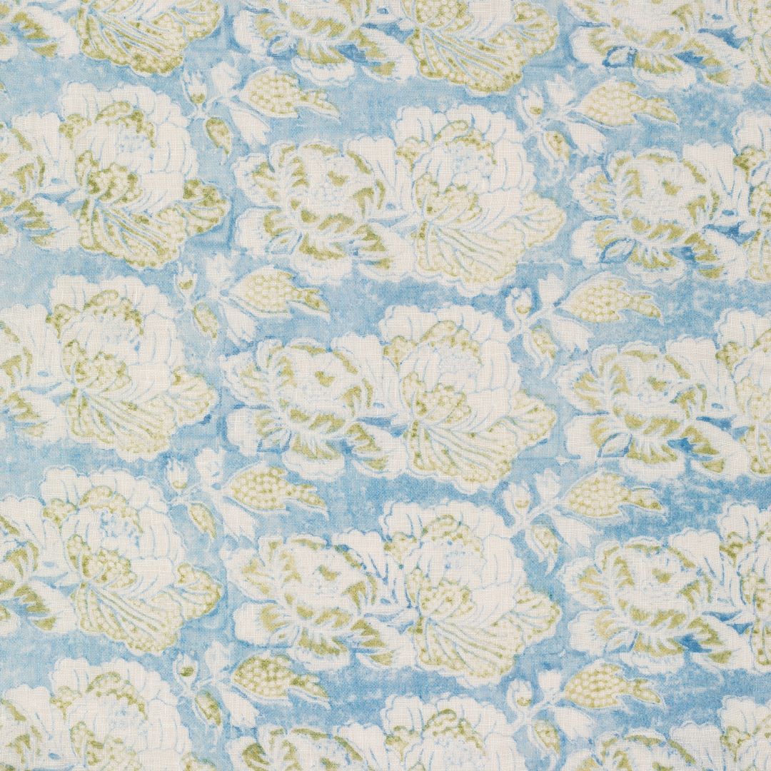 Detail of fabric in a floral print in white and light green on a blue field.