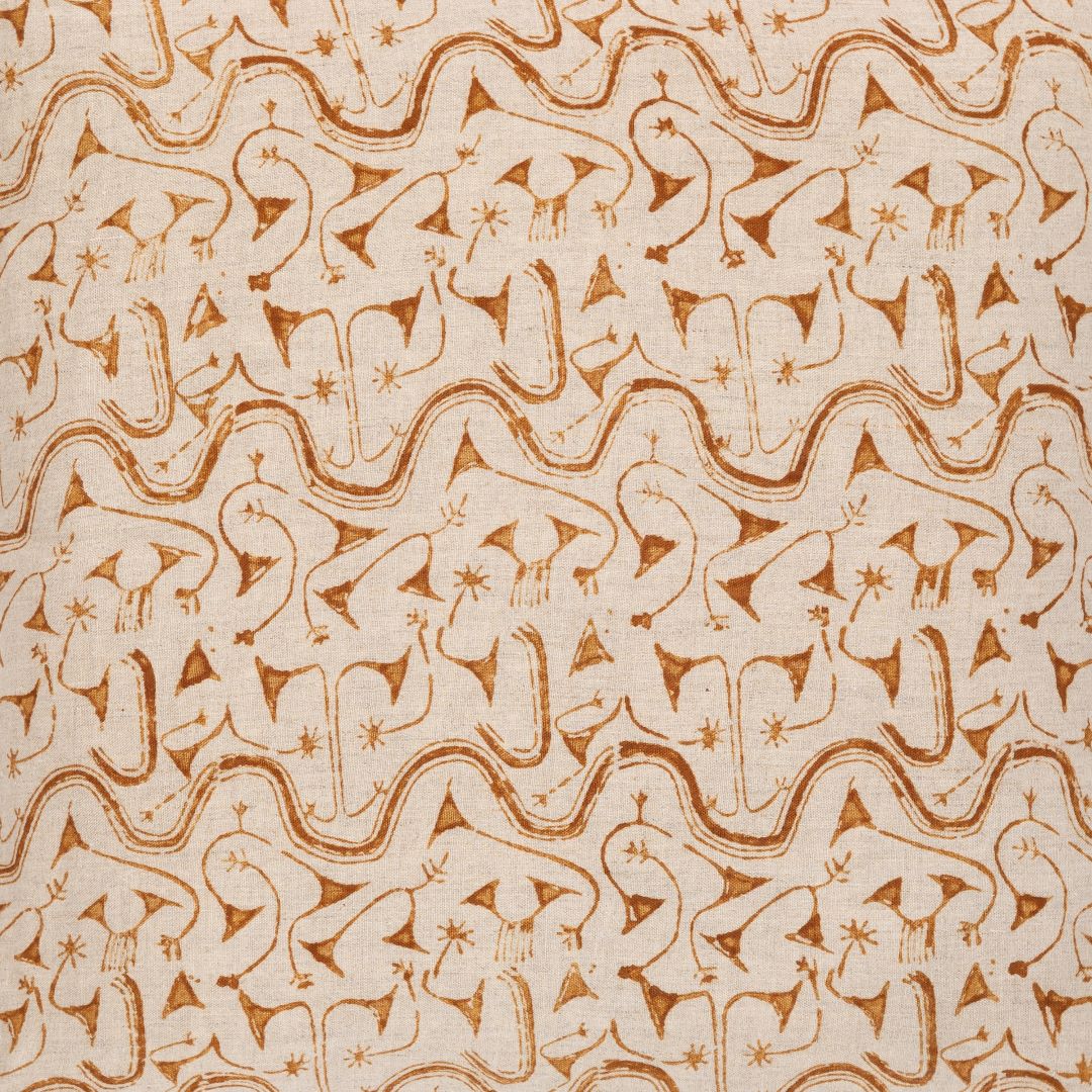 Detail of fabric in an abstract tribal print in orange on a tan field.