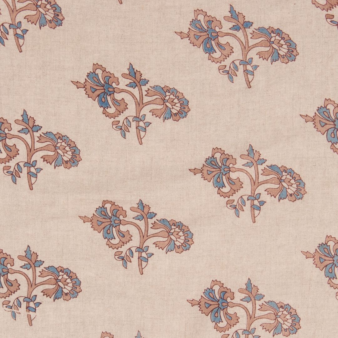 Detail of fabric in a floral grid print in tan and blue on a cream field.