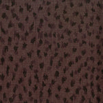 Fabric in a cheetah print in black on a brown field.