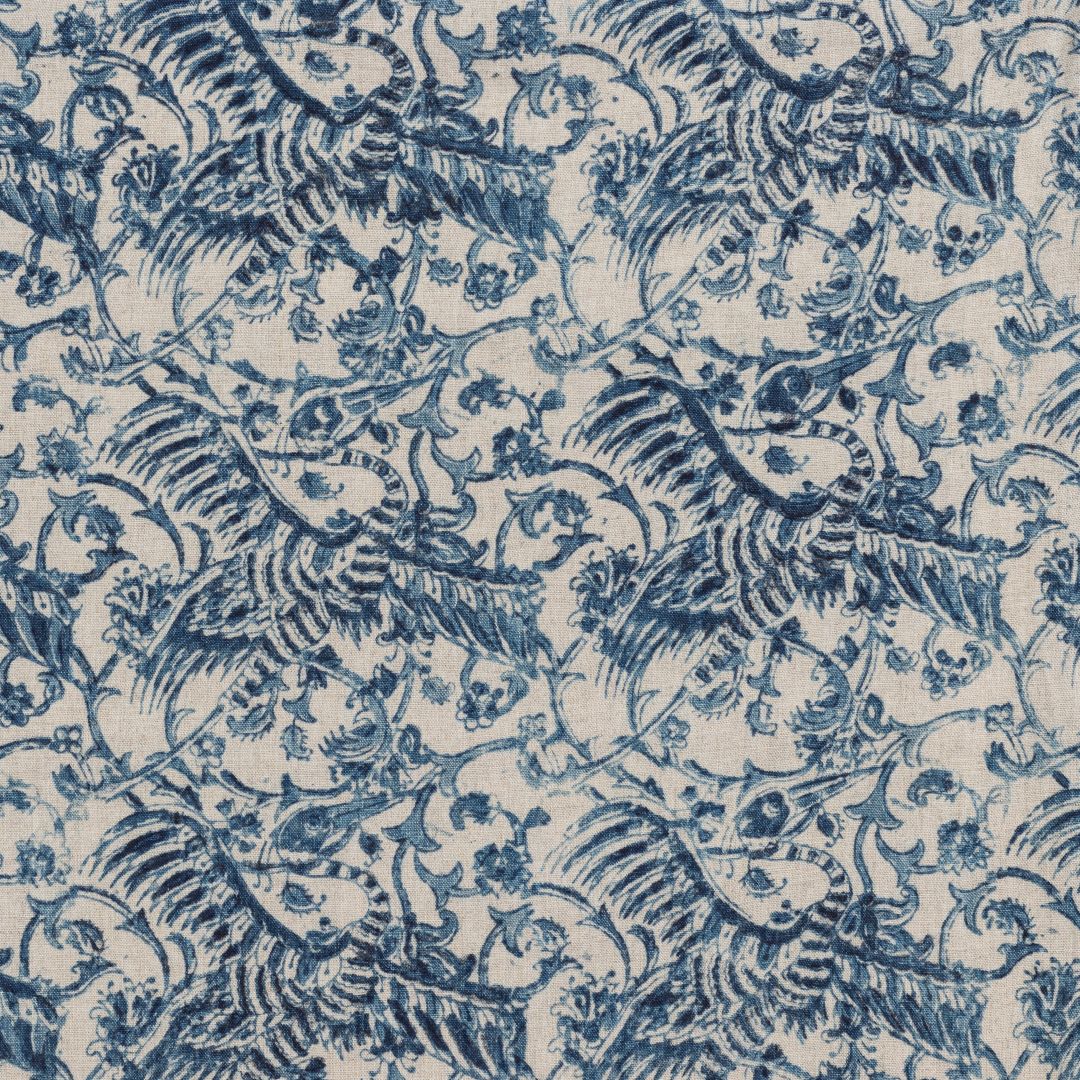 Detail of fabric in intricate flower and crane print in navy on a tan field.