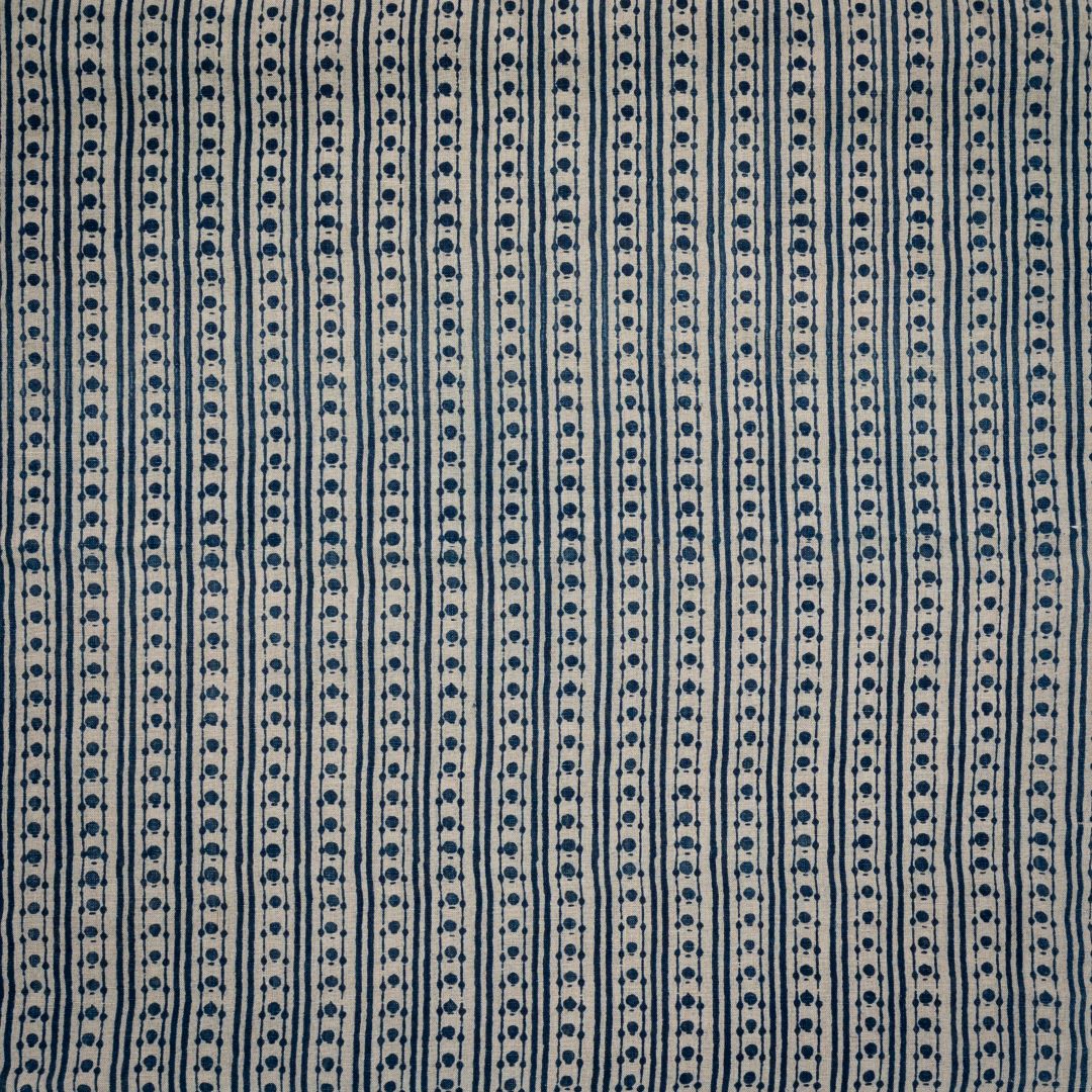 Detail of fabric in a geometric striped print in navy on a tan field.