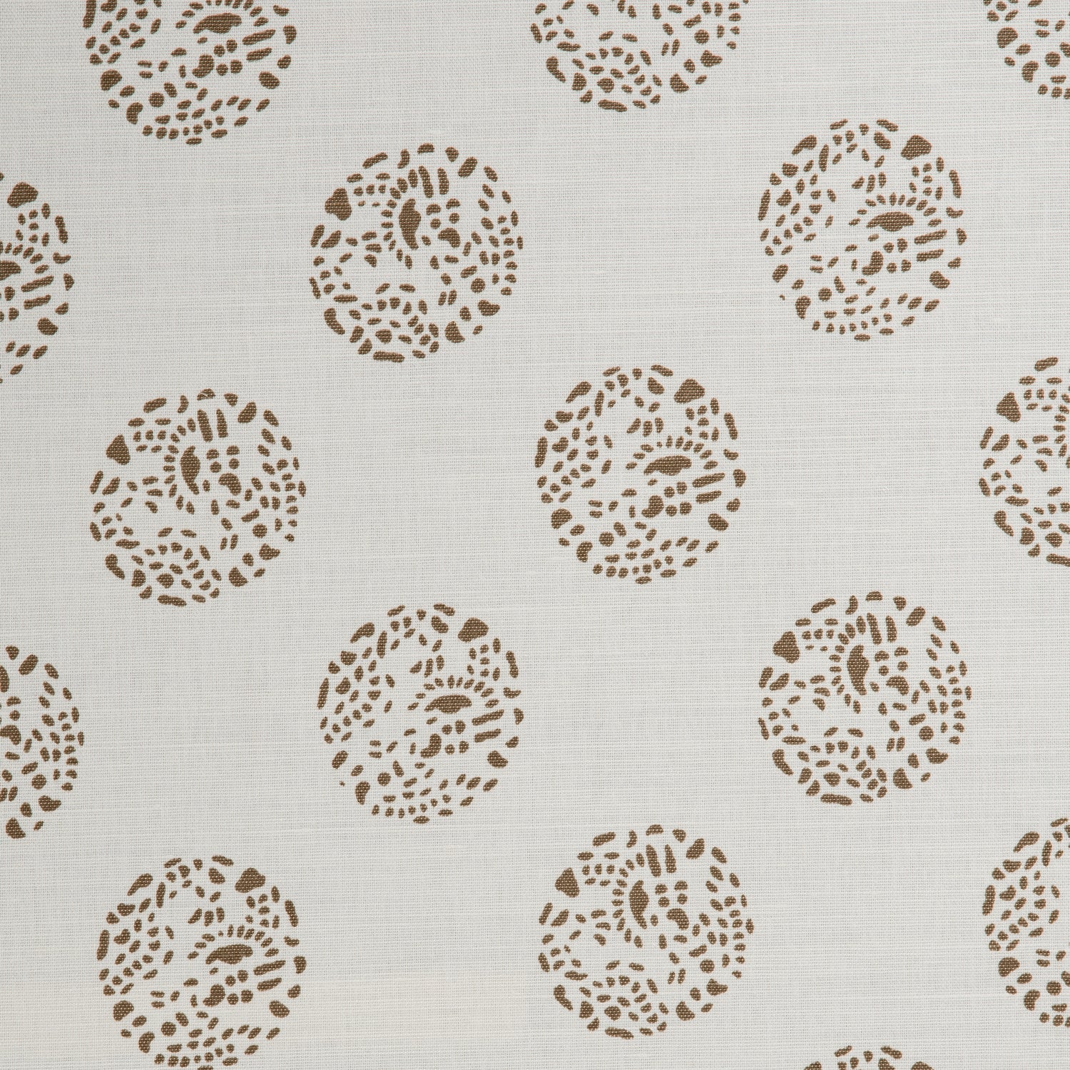 Detail of a printed cotton fabric in a repeating dotted pattern in brown on a cream field.