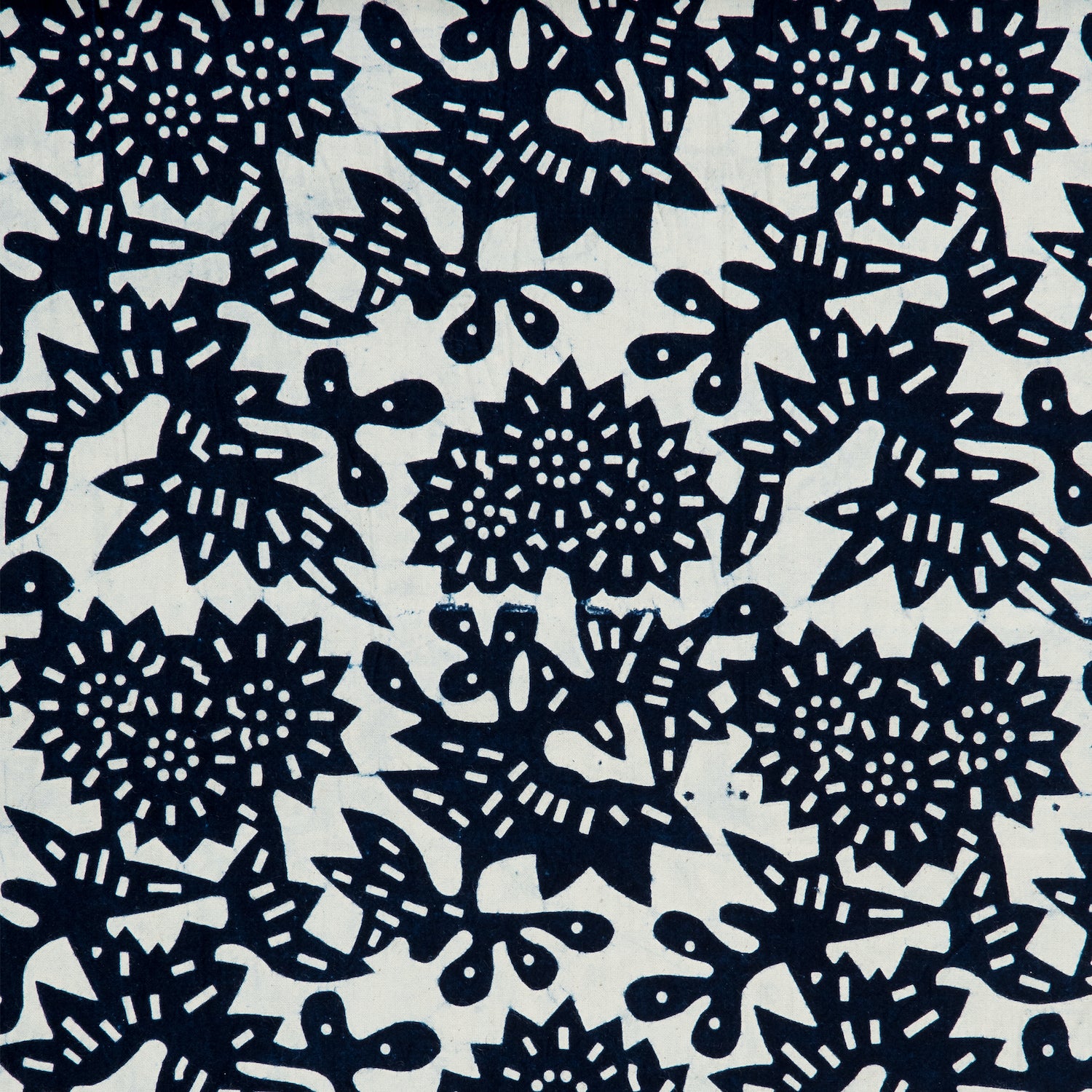 Detail of a linen-cotton fabric in a repeating geometric flower pattern in indigo on a white field.