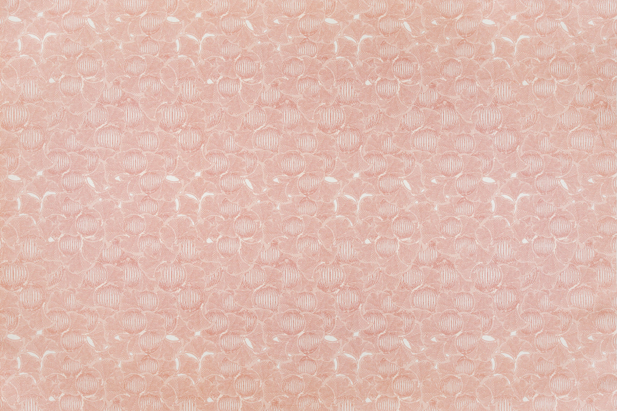Detail of fabric in a dense petal print in shades of peach on a white field.