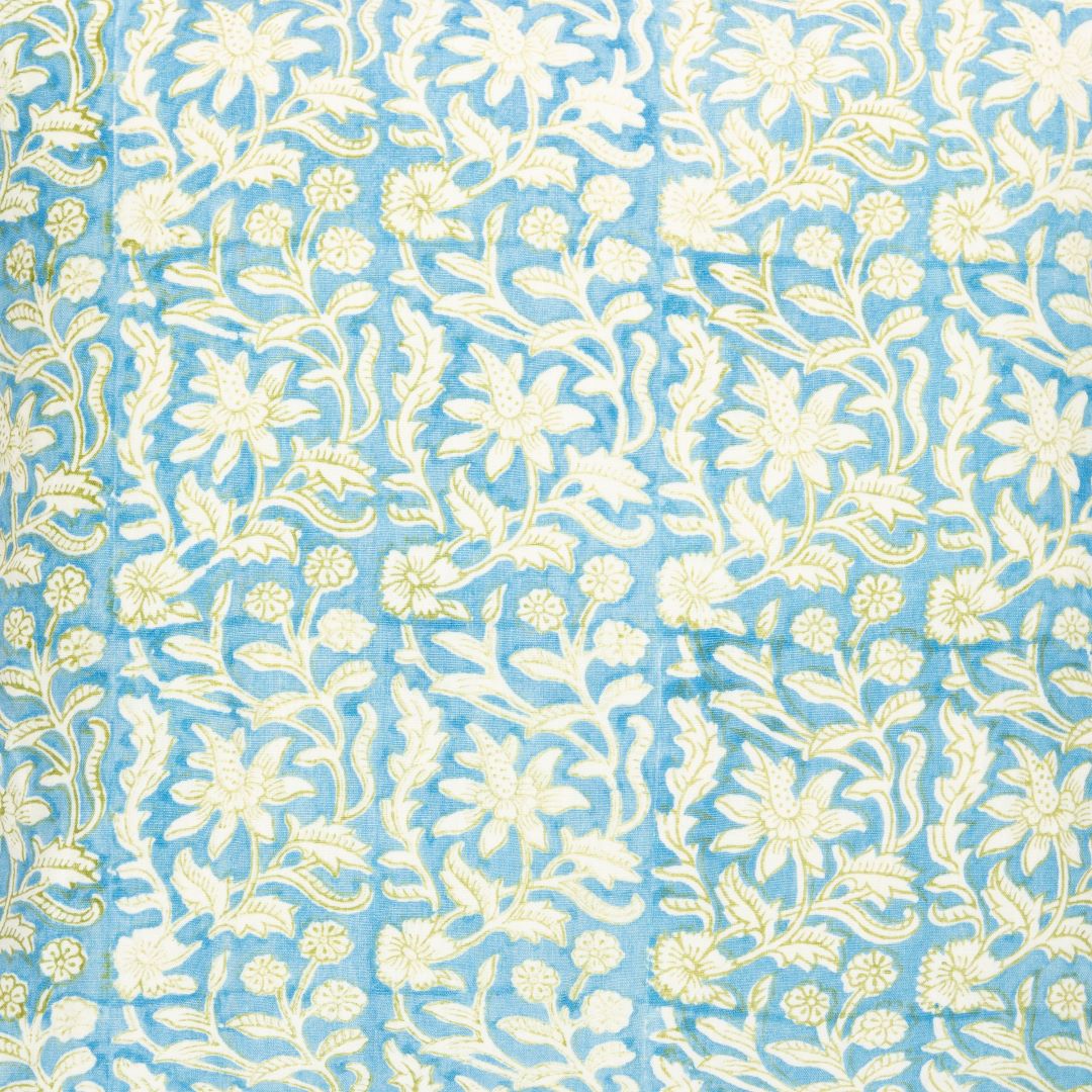 Detail of fabric in a floral block print in white and yellow on a blue field.