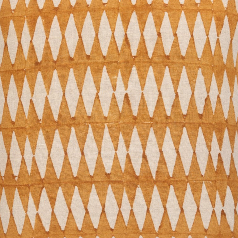 Detail of fabric in a diamond stripe print in mustard yellow on a cream field.