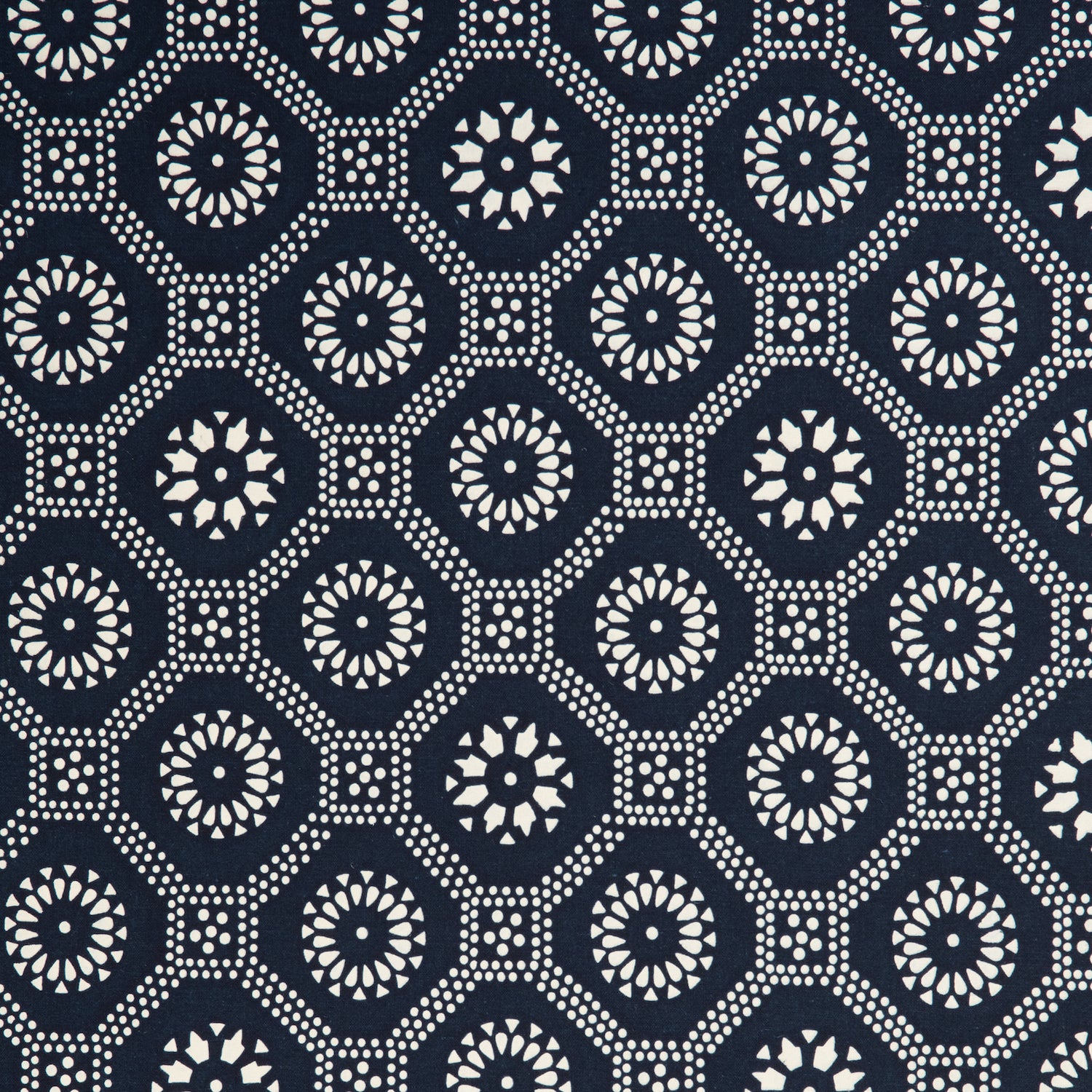 Detail of a cotton fabric in a floral gridded honeycomb pattern in white on an indigo field.