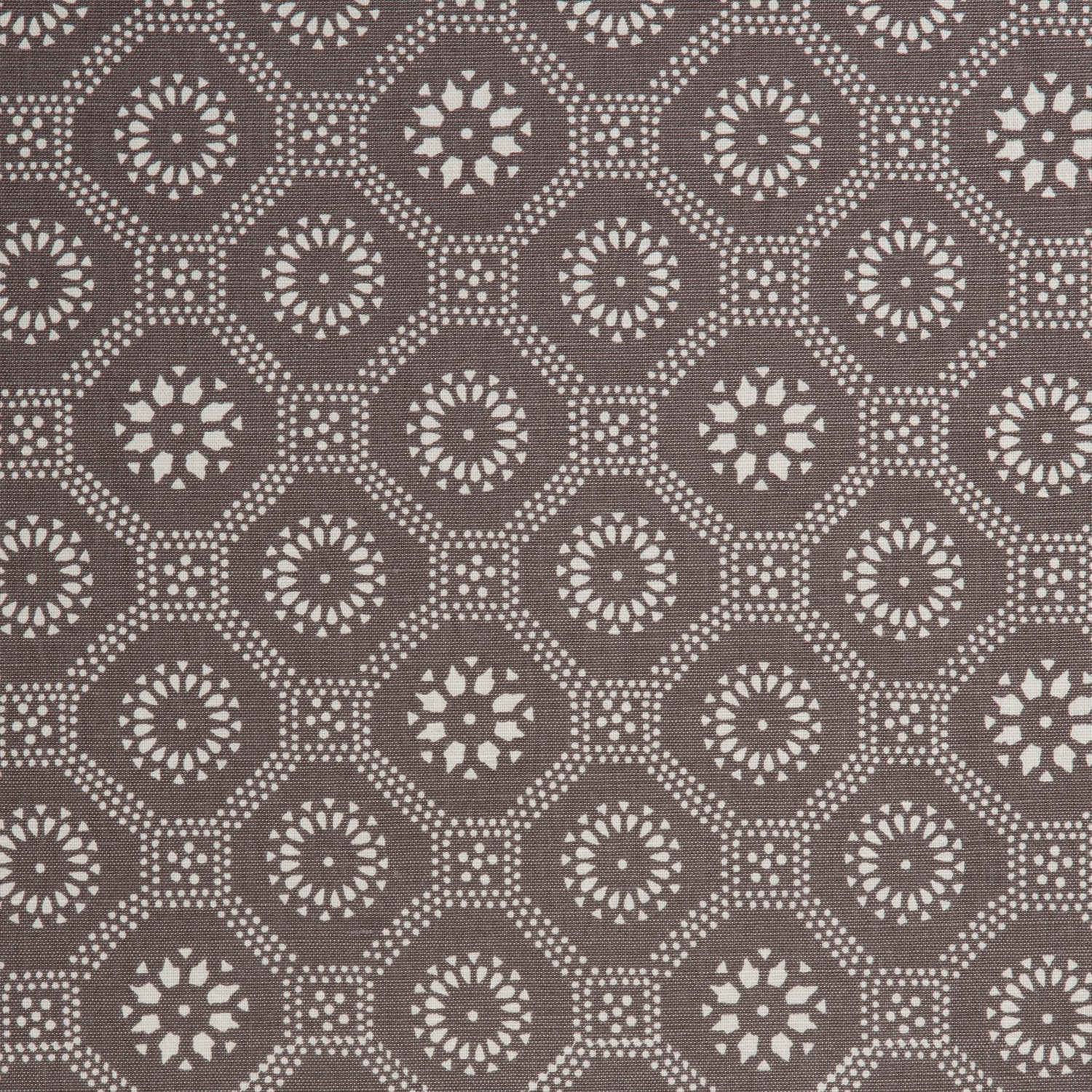 Detail of a cotton fabric in a floral gridded honeycomb pattern in white on a brown field.