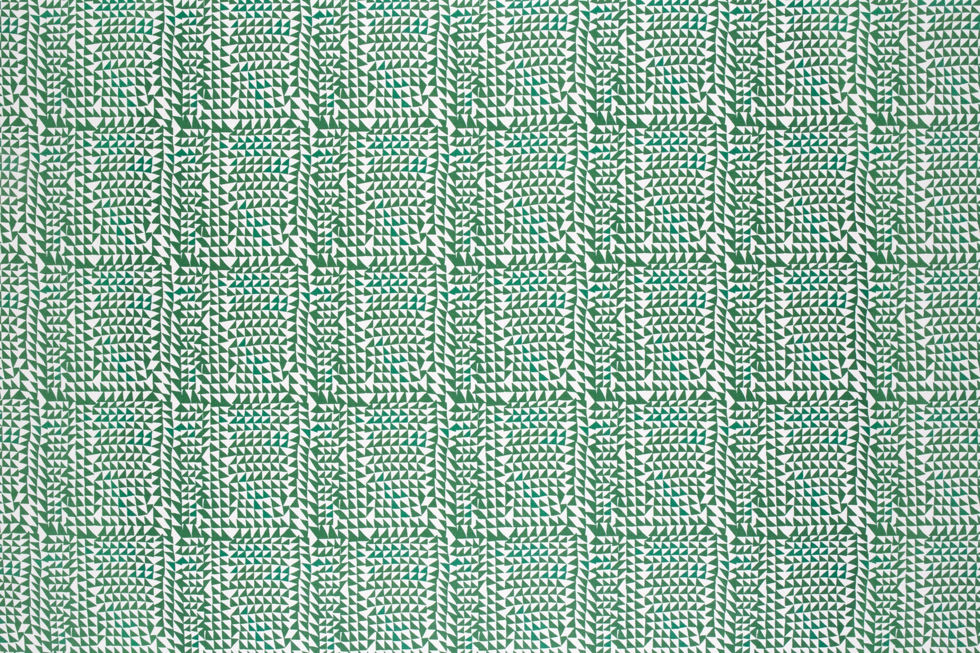Detail of fabric in a dense triangle grid print in green on a white field.