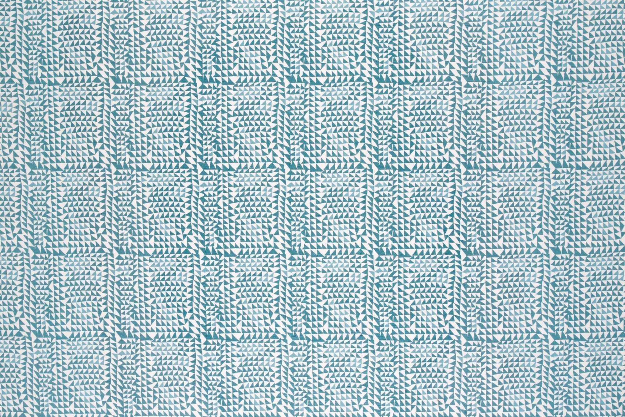 Detail of fabric in a dense triangle grid print in shades of blue on a white field.