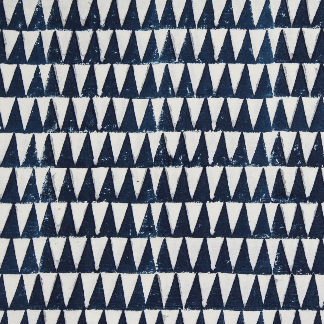 Detail of fabric in a repeating triangle print in navy on a white field.