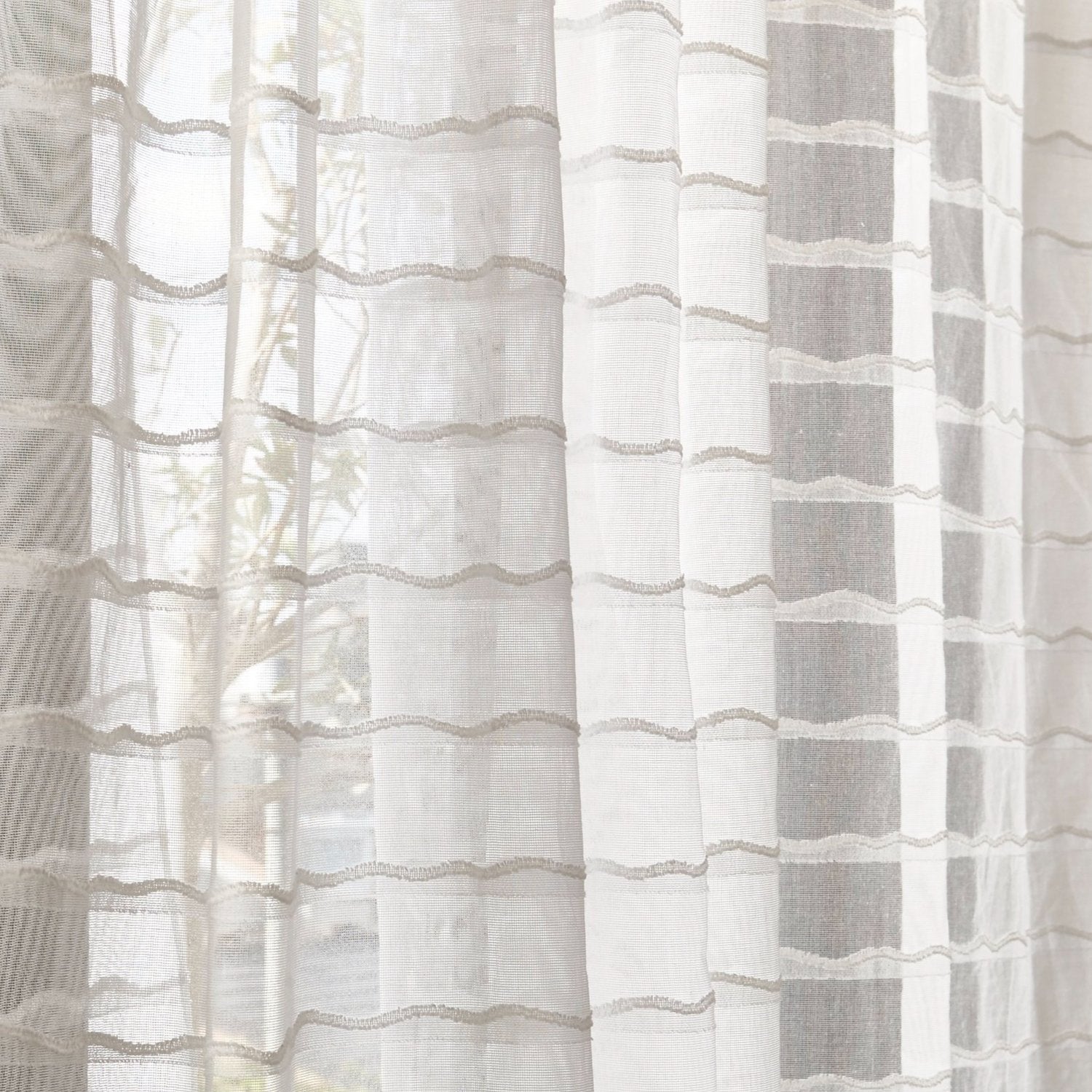 Draped sheer fabric in a wavy stripe pattern in ivory.