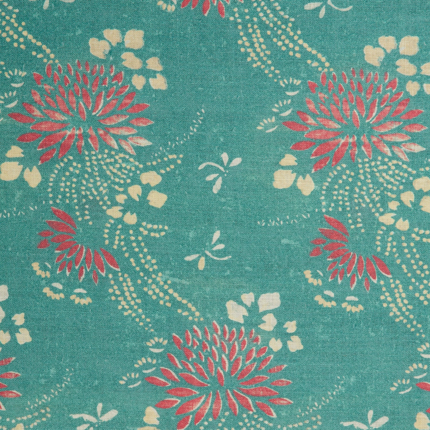 Detail of a linen fabric in a floral and dot pattern in red and beige on a turquoise field.