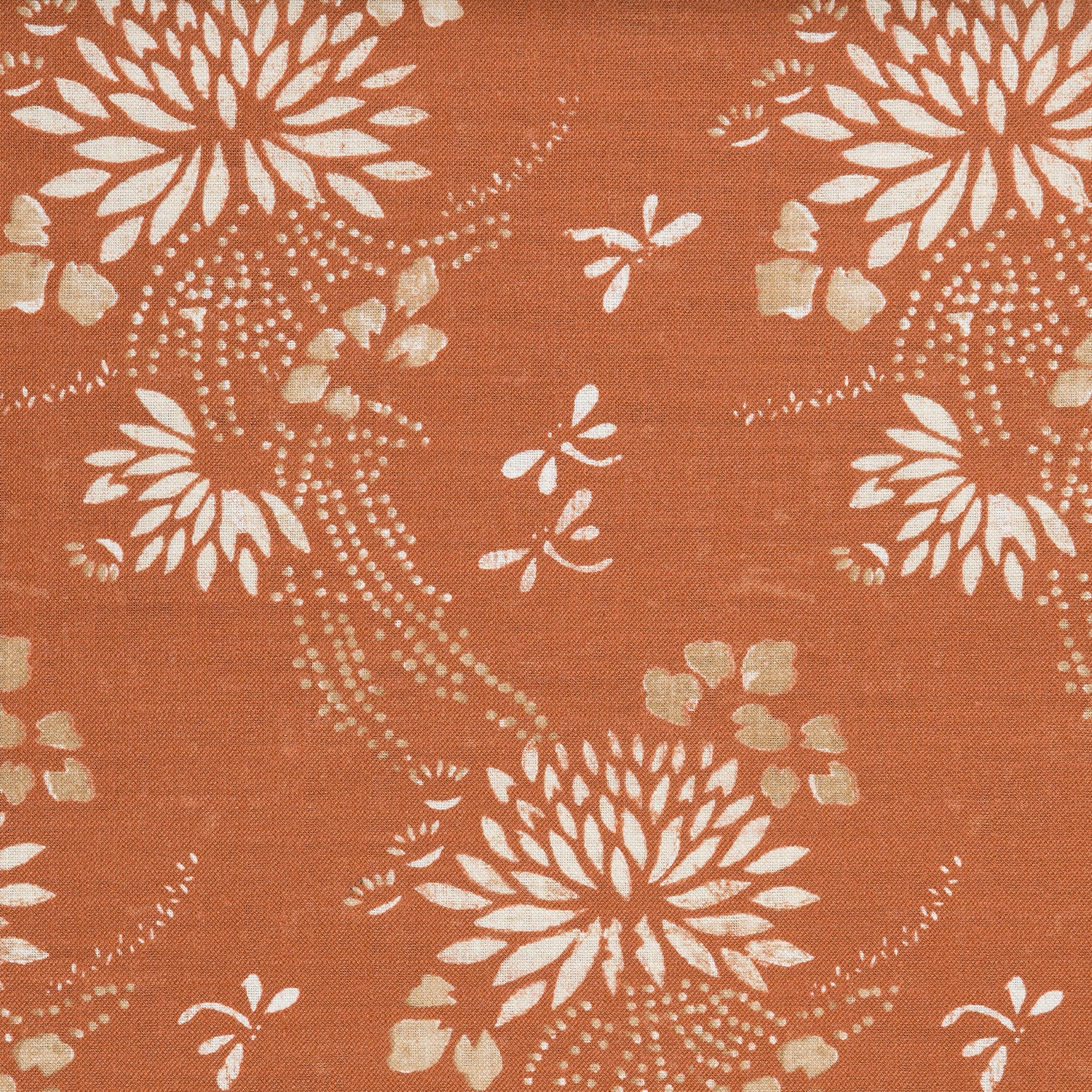 Detail of a linen fabric in a floral and dot pattern in white and gold on a rust field.