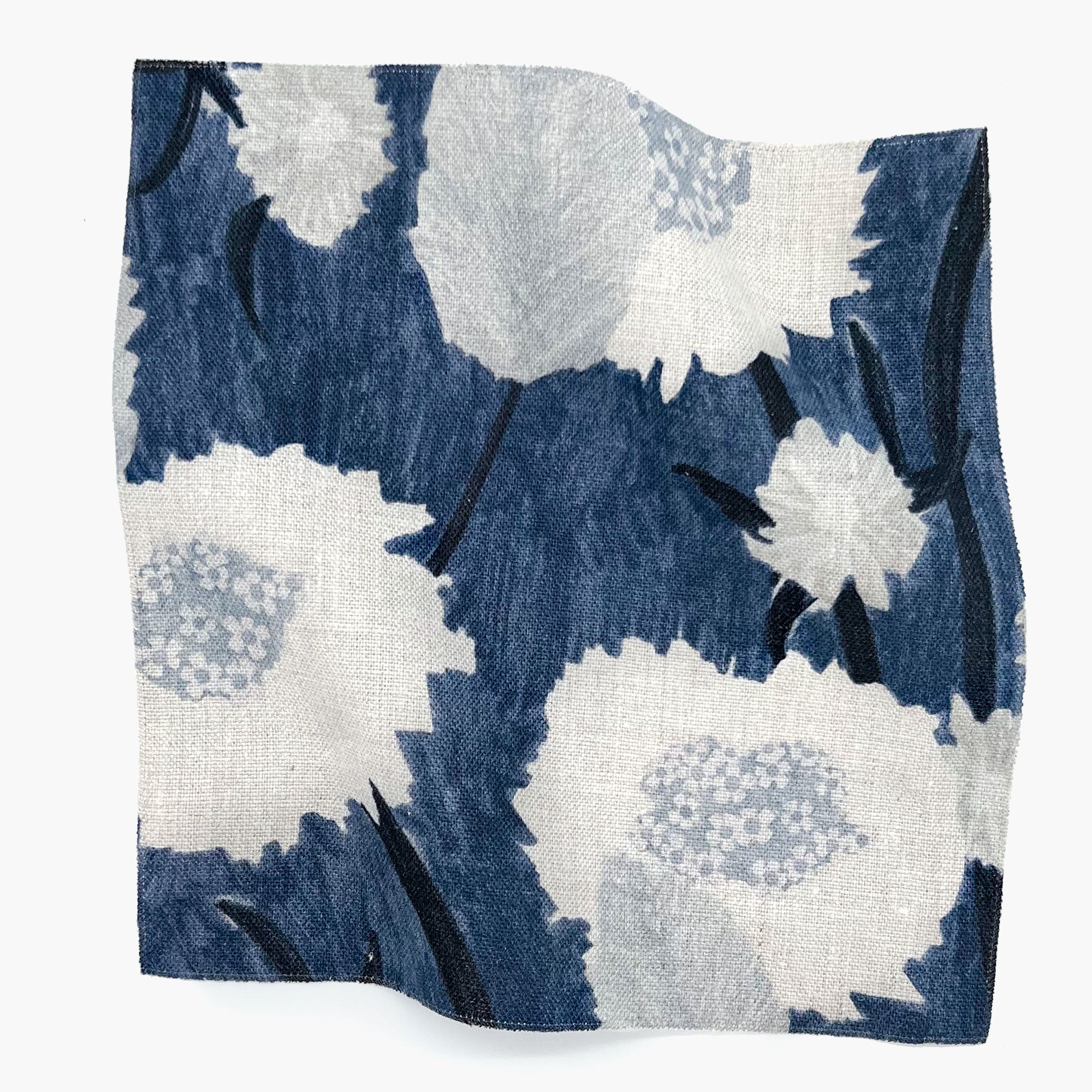 Square fabric swatch in a playful floral print in shades of white and gray on a navy field.